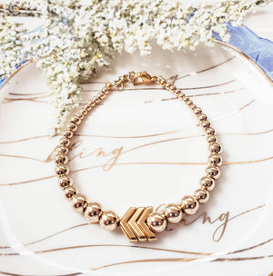 Minimal design. Maximum impact. 14k Gold filled graduated beaded bracelet with 3 gold plated chevrons, True luxury and perfect to showcase your Everyday Awareness. - Down Syndrome Boutique